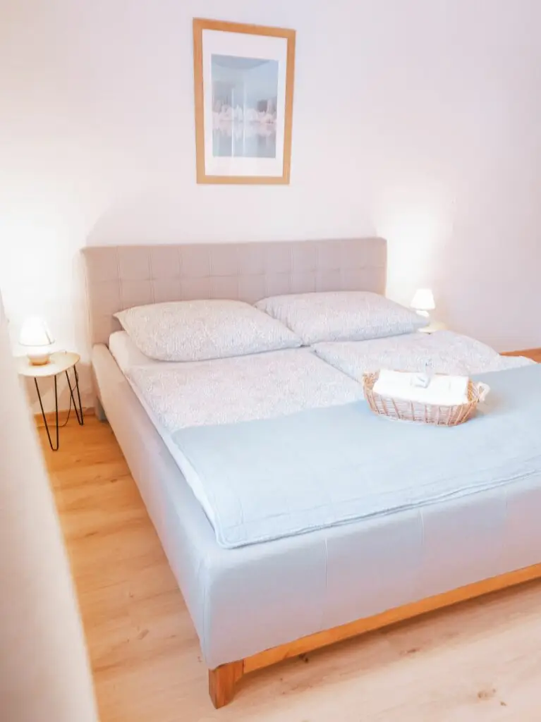 Ein Bett in einem Zimmer mit Holzböden in Grundlsee, Salzkammergut. Perfekt für einen erholsamen Urlaub in Österreich.