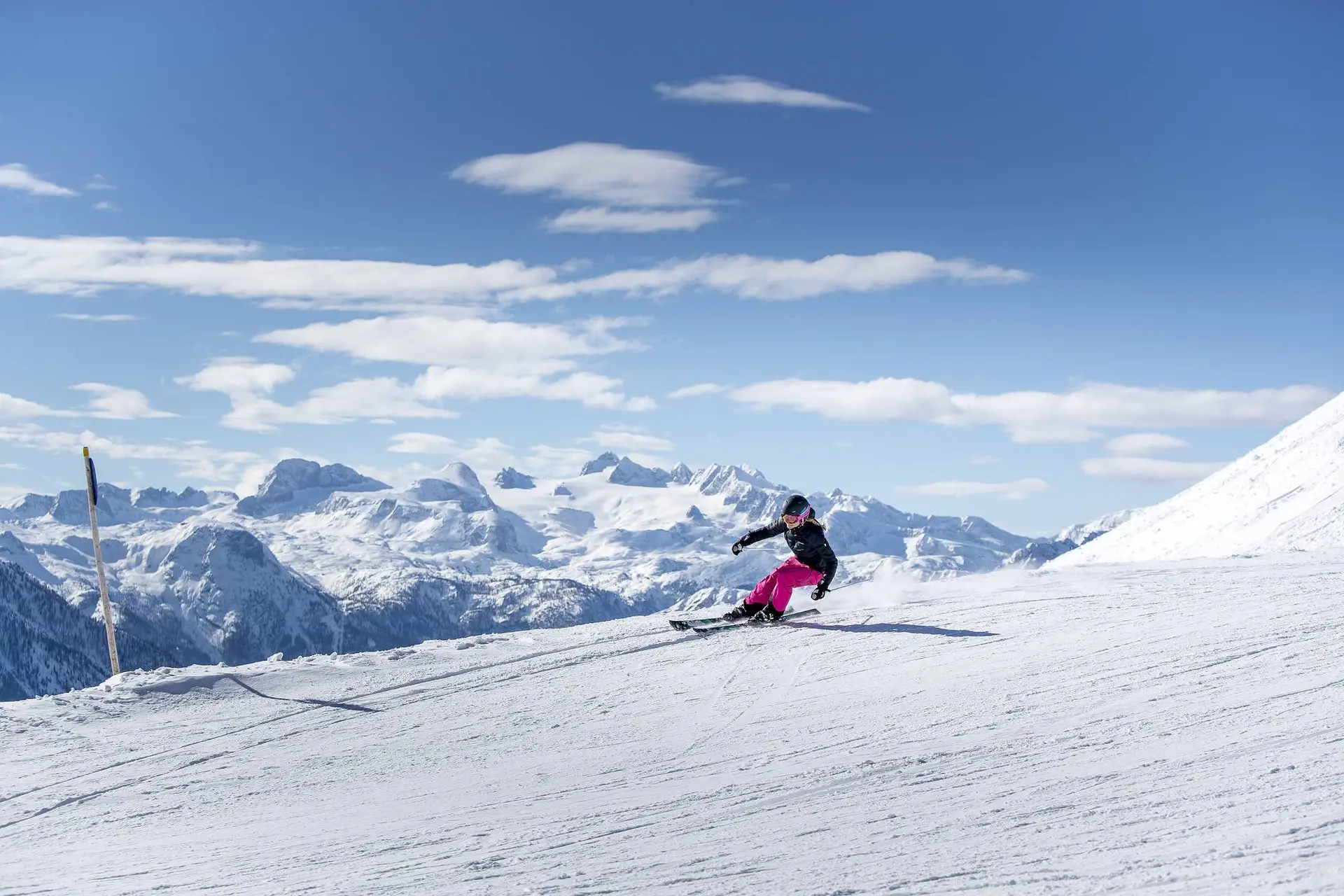 Eine Person, die ein aufregendes Skiabenteuer auf einem verschneiten Hang inmitten unberührter Berge genießt.